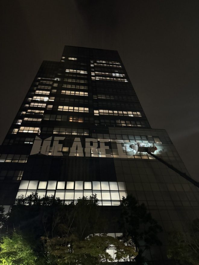 "Controversial: Massive 'WE ARE BACK' Banner for BTS Homecoming on HYBE Building!" — BTS anniversary celebration, HYBE building banner, K-pop homecoming event