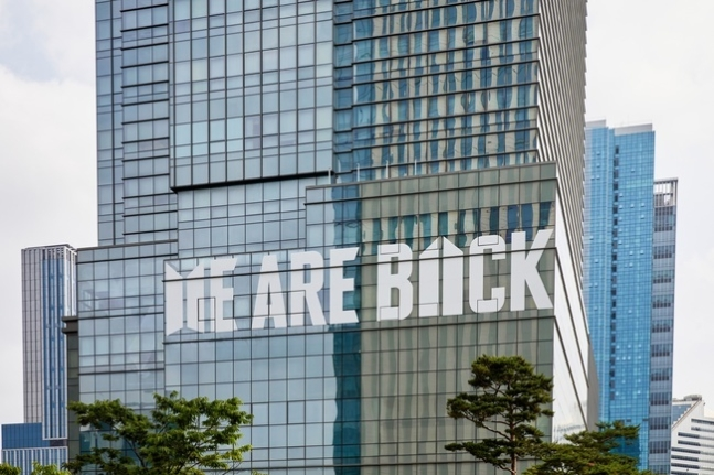"Media frenzy as #BTS returns in full force, HYBE building wrapped in bold statement 'WE ARE BACK' - controversy ensues!" — BTS FESTA celebration, Media coverage BTS return, HYBE Building event coverage